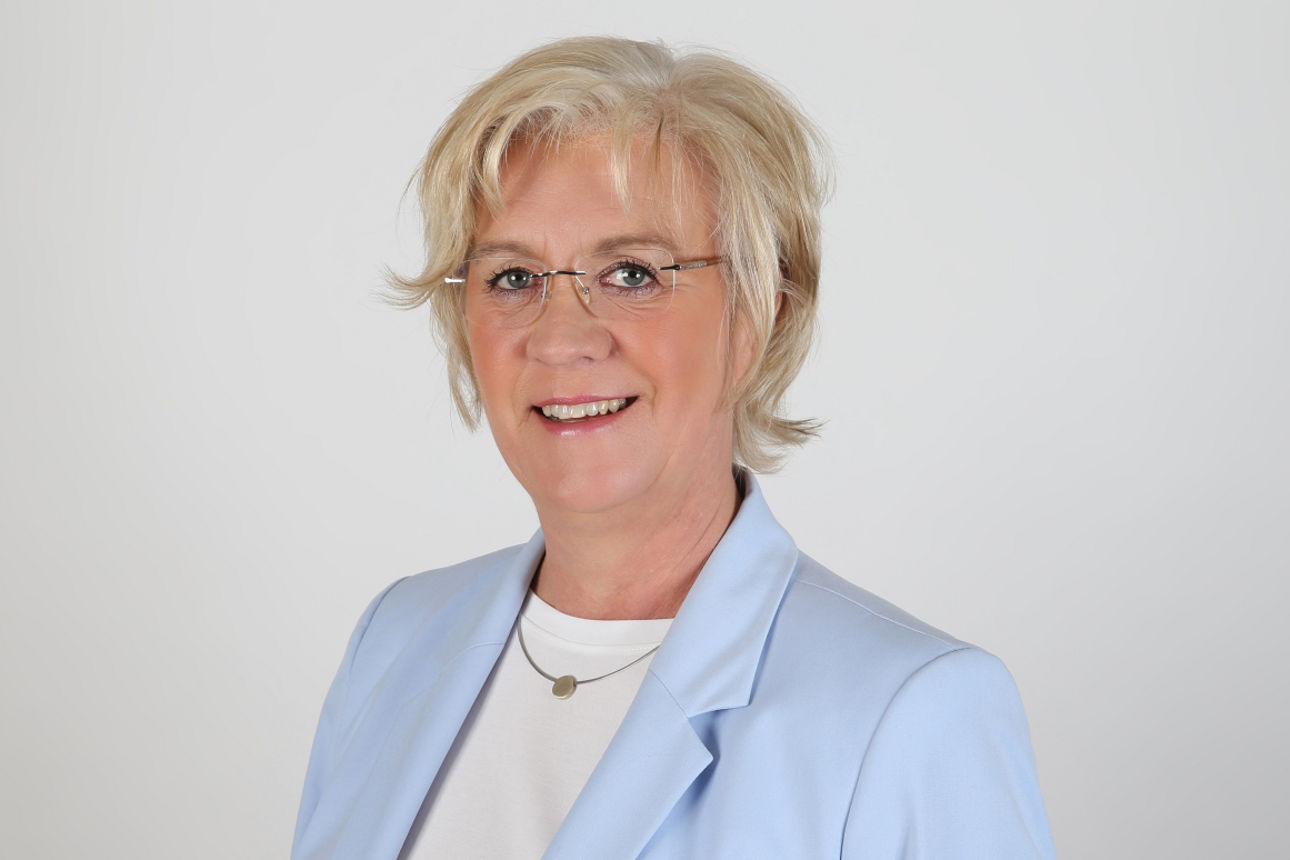 Eine lächelnde Frau schaut in die Kamera.