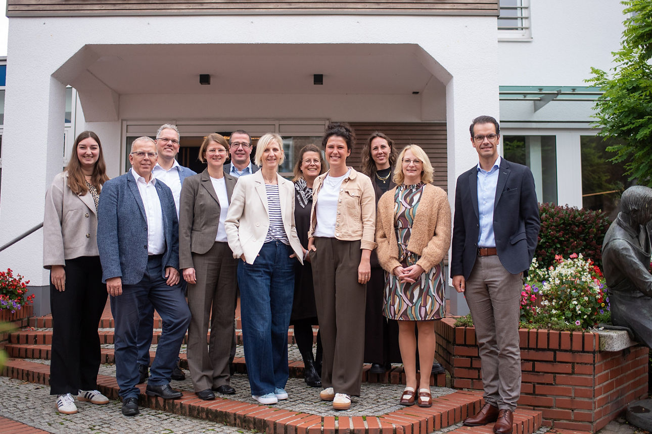 Sieben Frauen und vier Männer stehen zu einem Gruppenbild vor der Volksbank Schermbeck