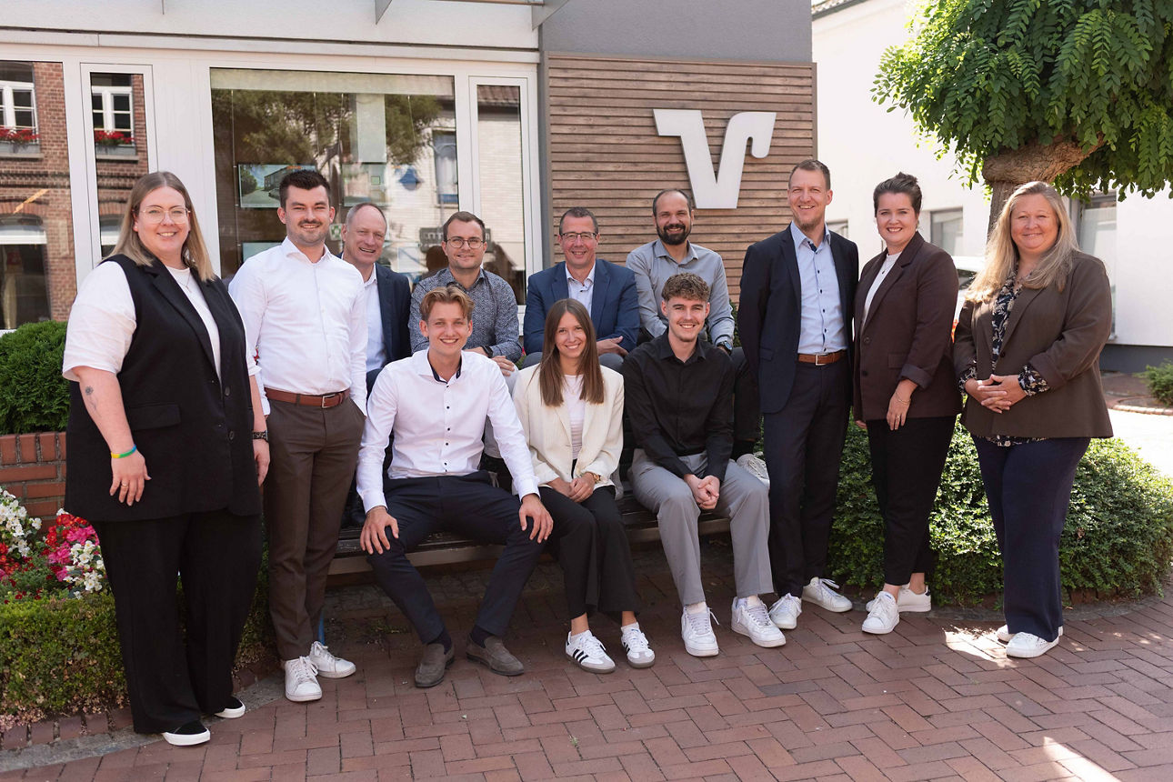 Insgesamt 9 Jubilare und 3 neue Auzubildende der Volksbank Schermbeck im Gruppenbild vor der Bank