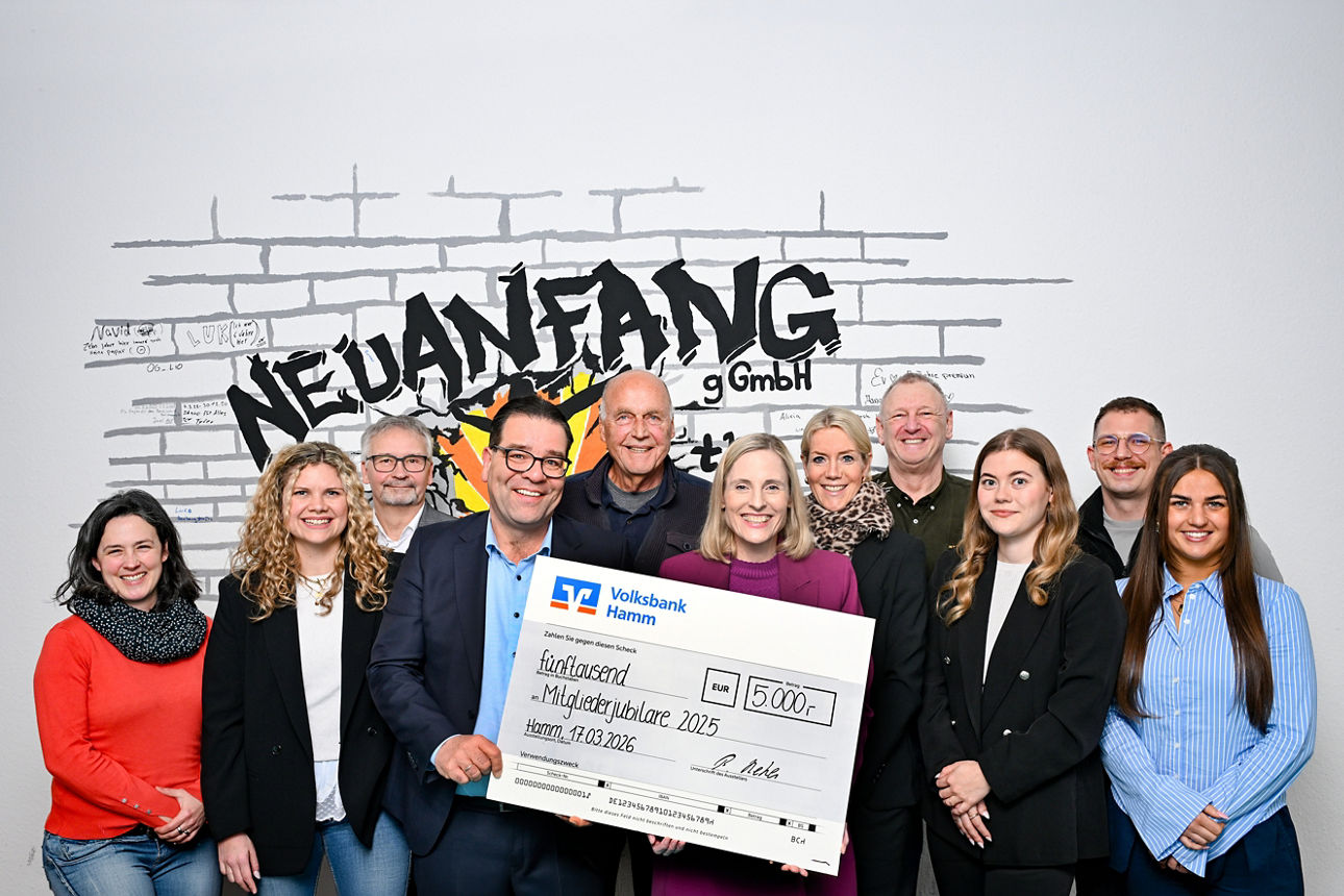 Burkhard Reher, Regionaldirektor der Volksbank Hamm (4. v. l.), hält den 5000-Euro-Scheck bei der symbolischen Übergabe