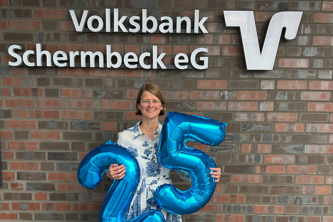Jubilarin Sonja Krämer mit den blauen Ballonzahlen 2 und 5 in den Händen.