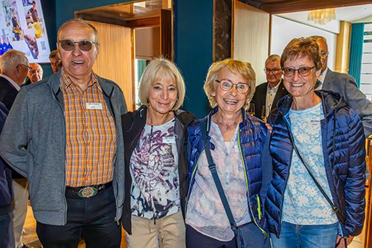 Ein Mann und drei Frauen lächeln in die Kamera