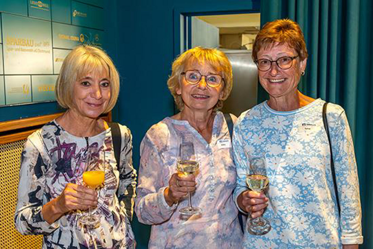 Drei Frauen lächeln in die Kamera