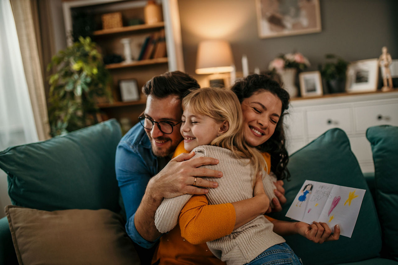 Familie kuschelt im Wohnzimmer.