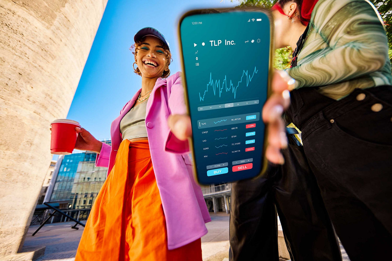 Junge Frau zeigt ihre Tradingapp.