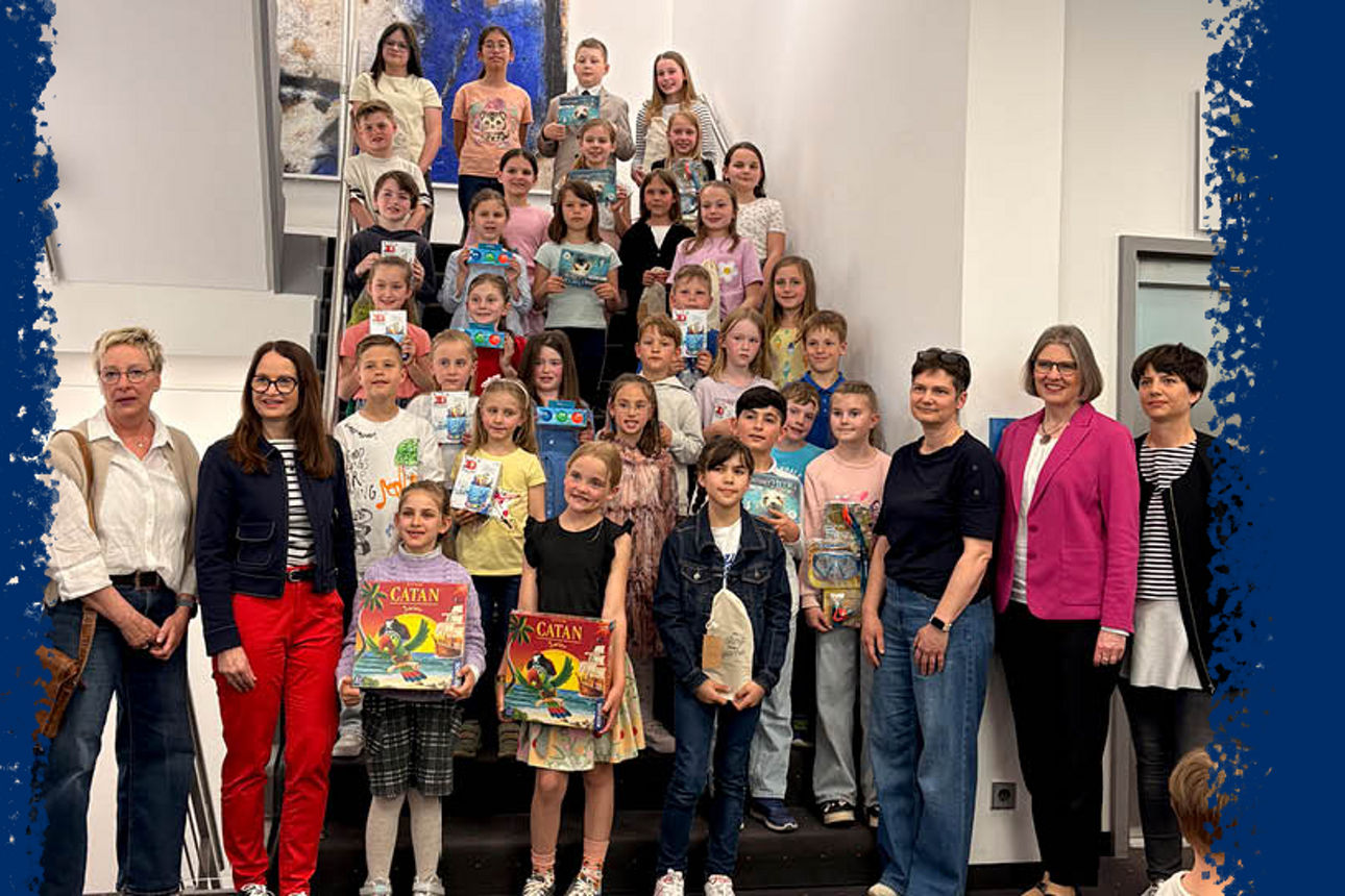 Viele Kinder und ein paar Erwachsene stehen in der Schalterhalle einer Bank mit Geschenken in der Hand.