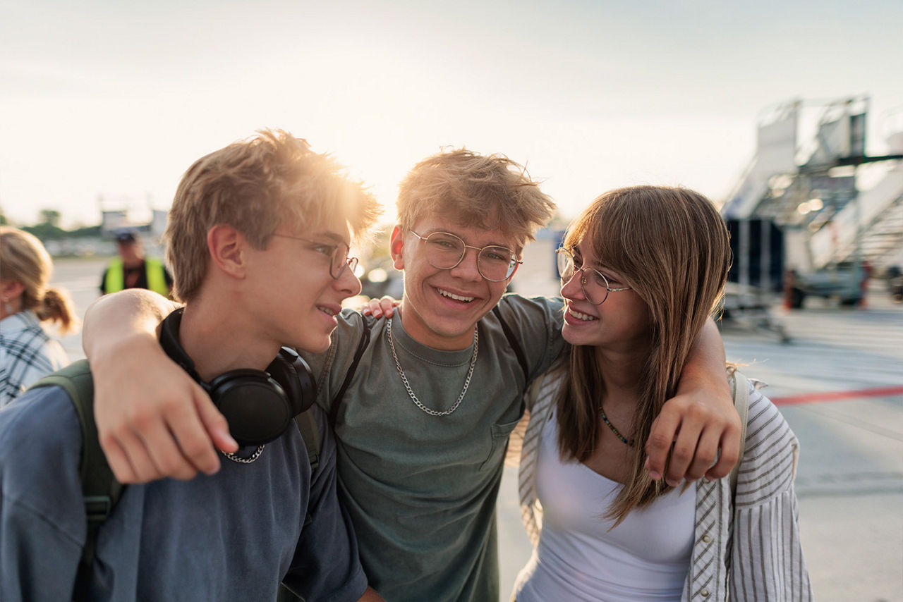 Drei Freunde stehen zusammen im Pausenhof