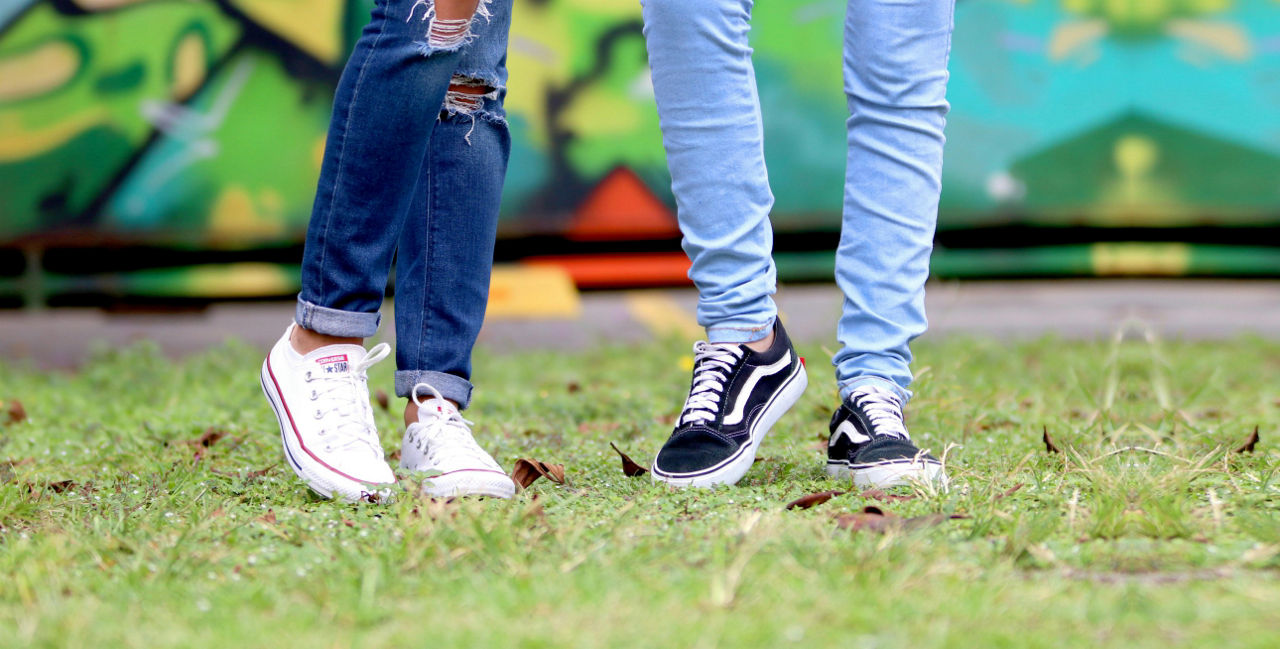 Jugendliche stehen auf dem Rasen. Man sieht nur die Beine und Schuhe