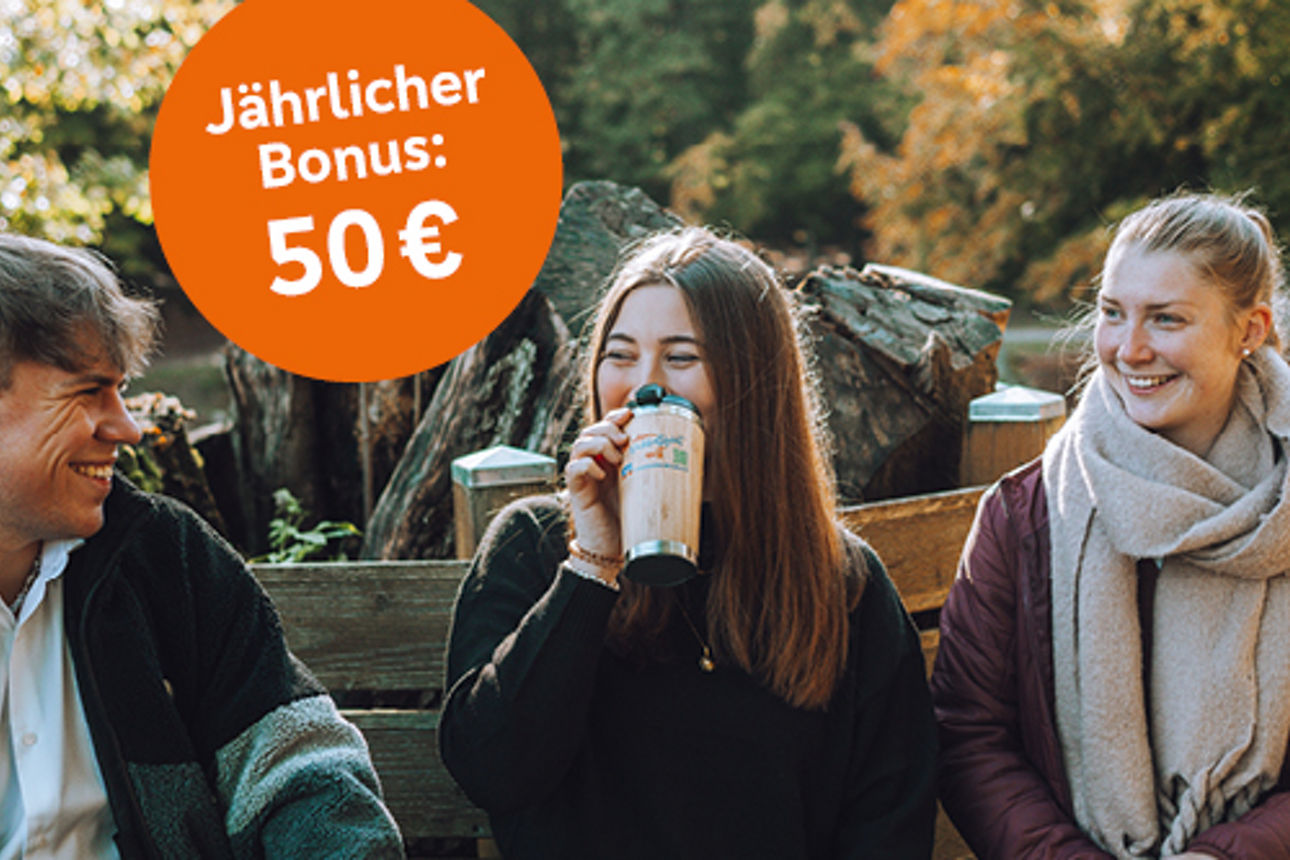 Drei Junge Mensche sitzen auf einer Bank im Park