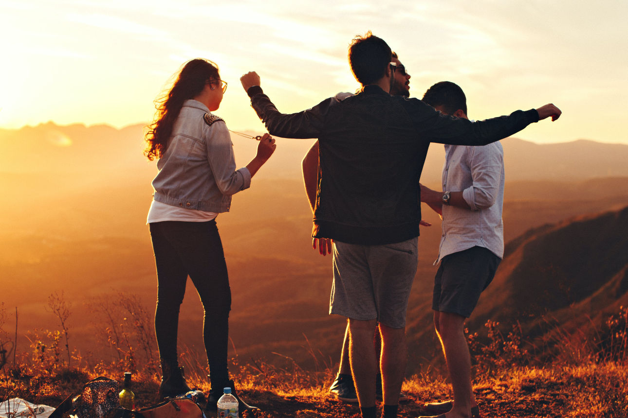Junge Erwachsene sind draußen, haben ausgelassene Stimmung und feiern.
