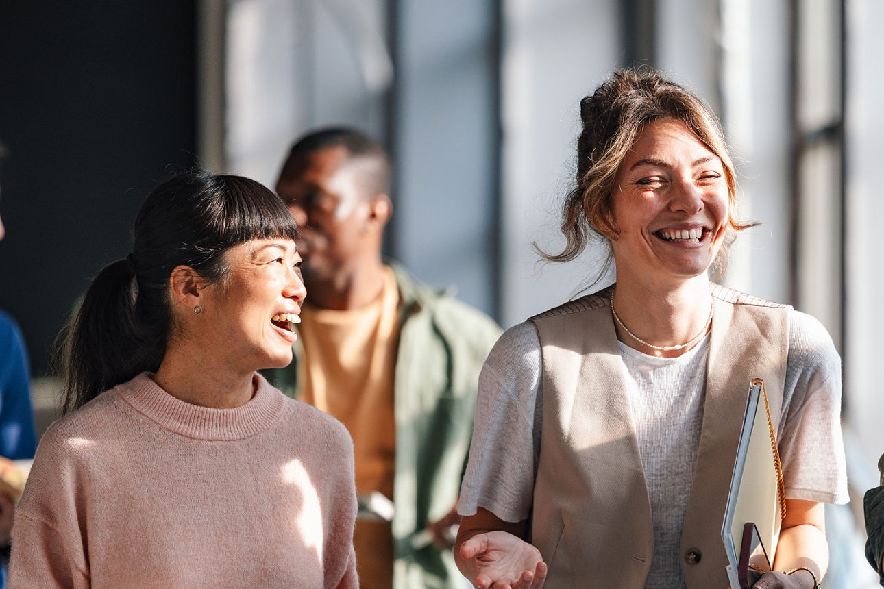 Drei junge Leute unterhalten sich lachend