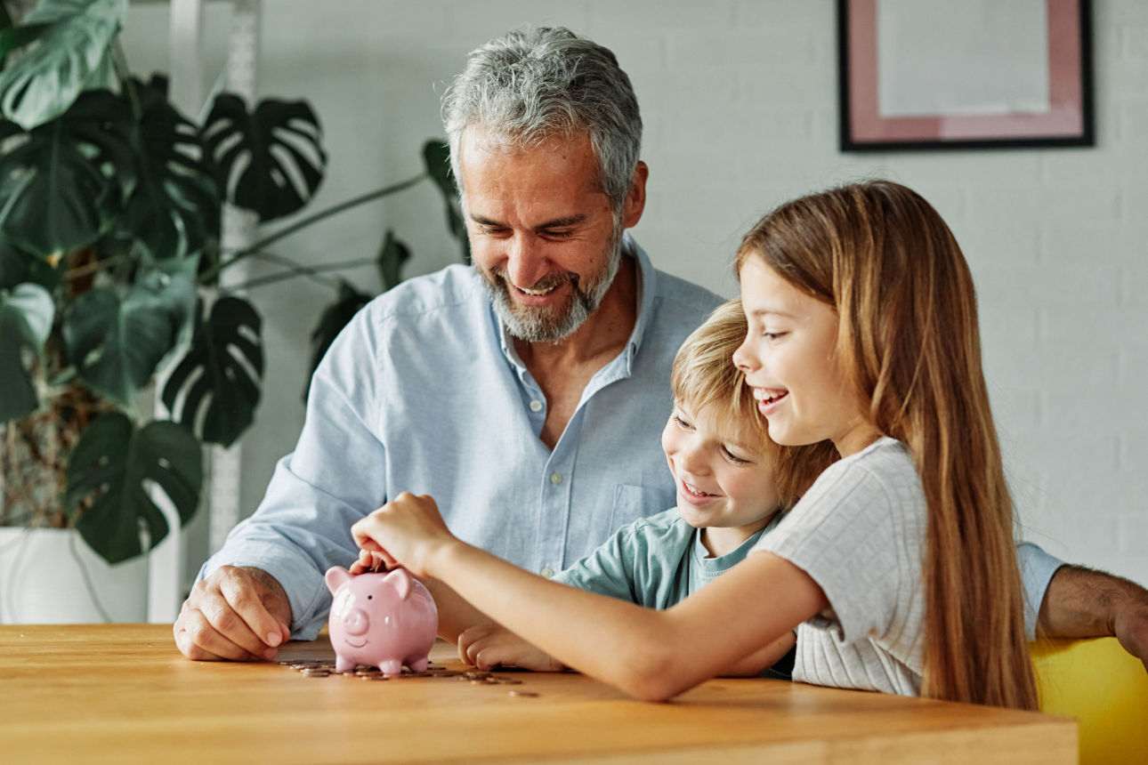 Mann mit Kindern und Spardose