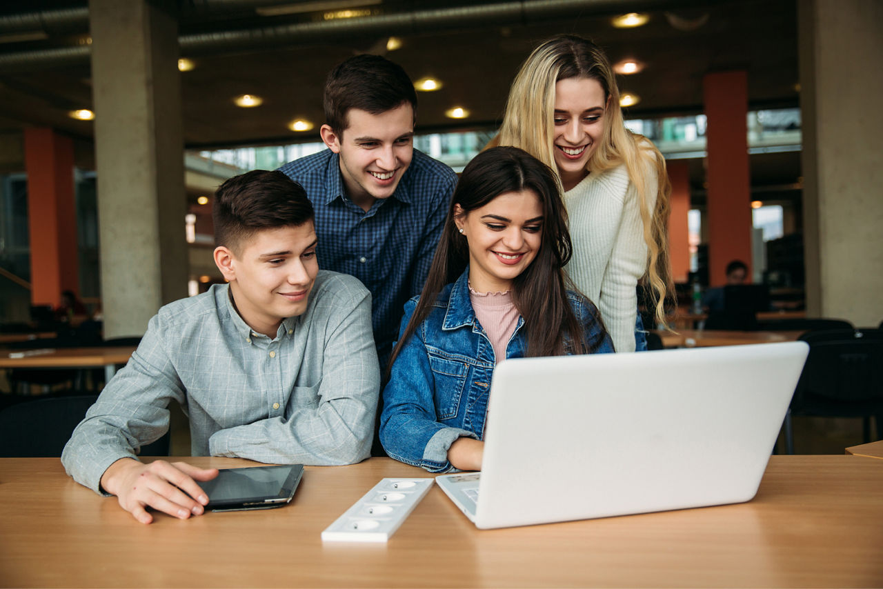 Vier junge Leute vor Laptop