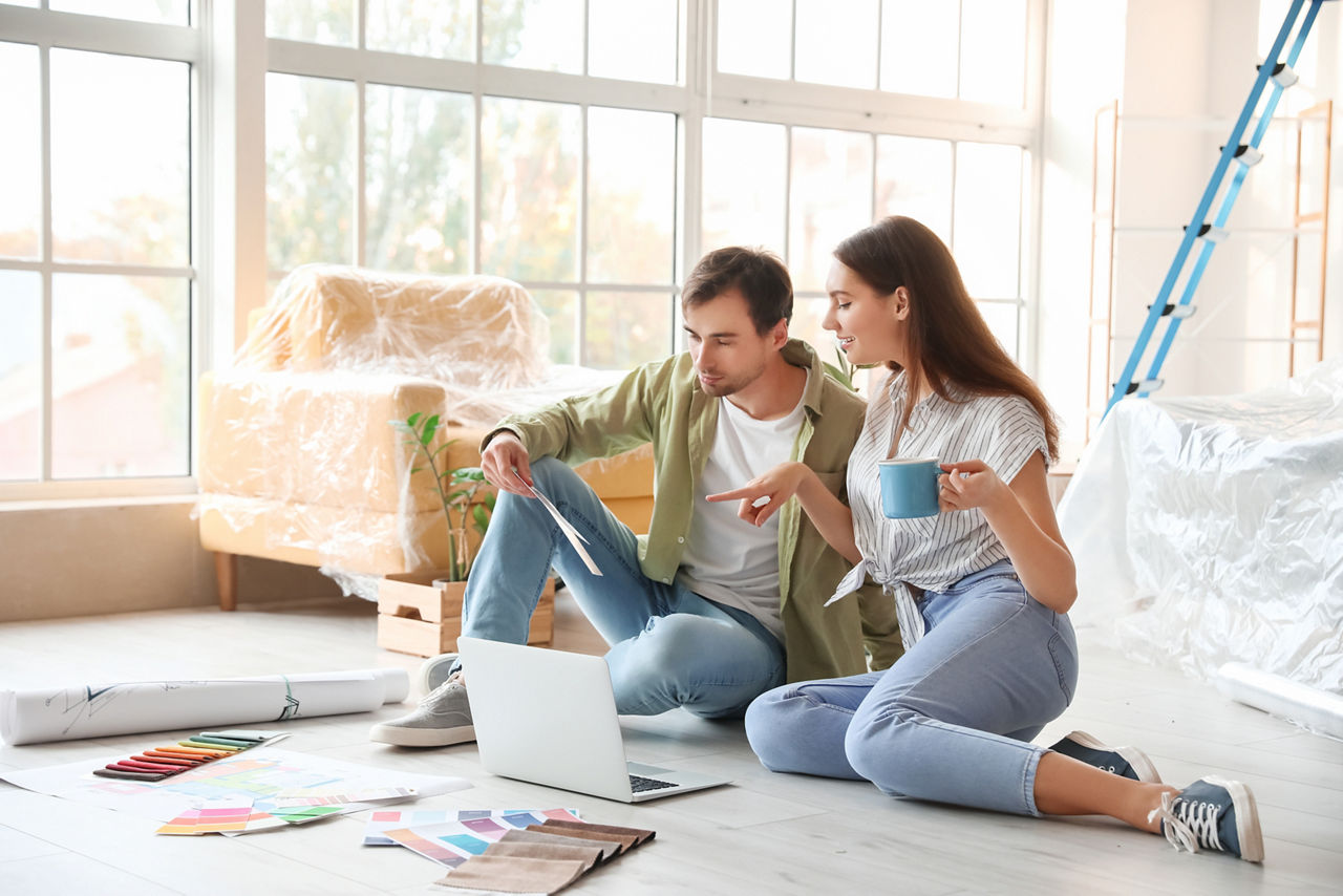 Paar in neuer Wohnung mit Laptop