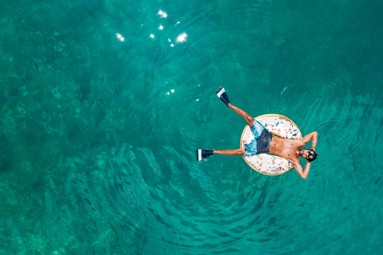 Mann auf Schwimmreifen im Meer