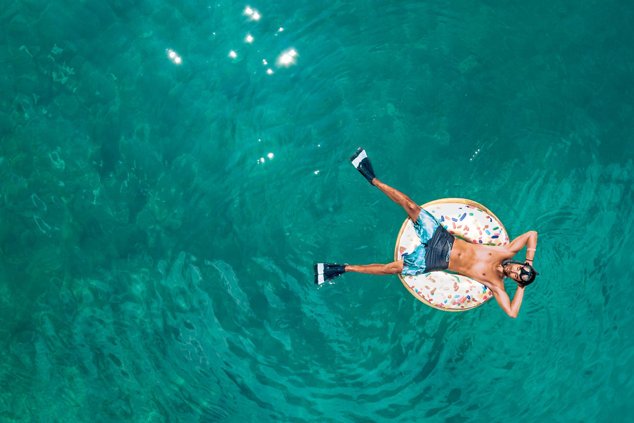 Mann auf Schwimmreifen im Meer