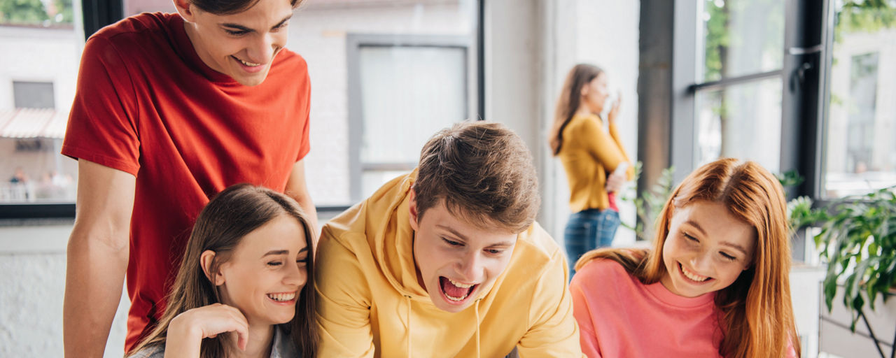 Zwei Jungen und zwei Mädchen lachend in einem Raum