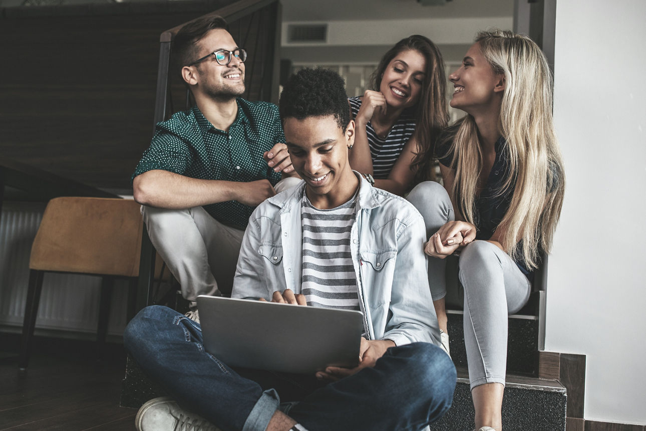 Eine Gruppe Jugendlicher sitzt um ein Laptop herum