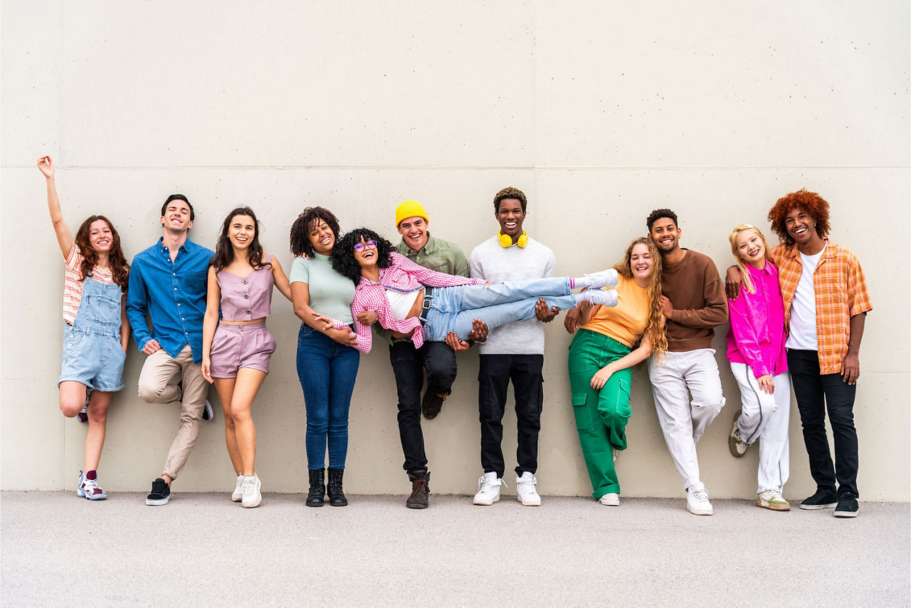 Fröhliche, verspielte, multiethnische Gruppe junger Freunde, die sich im Freien treffen
