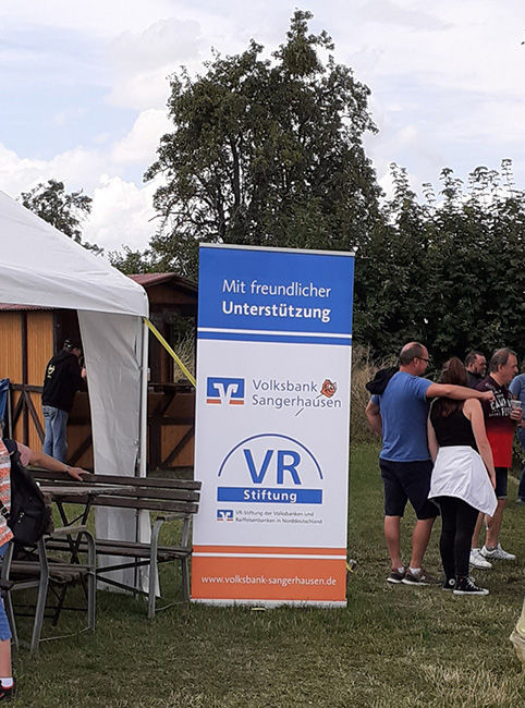 Roll-up-Banner der Volksbank Sangerhausen neben einer Bank und einem Zelt