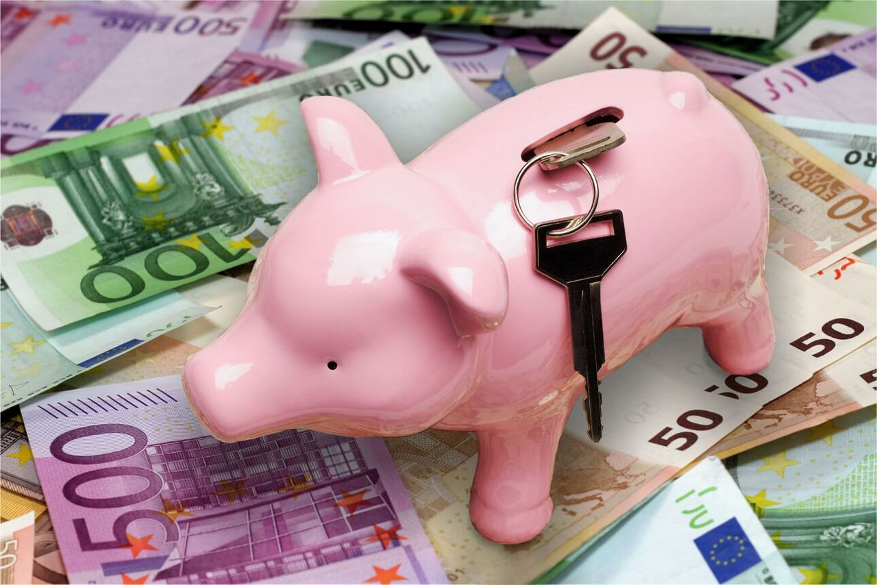 Sparschwein mit Schlüssel steht auf Geldscheinen 