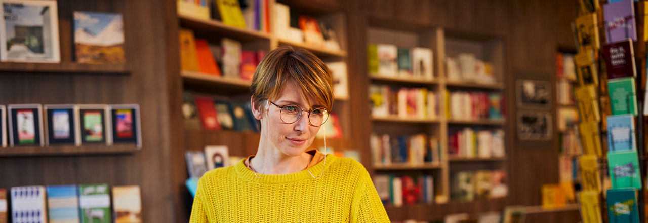 Eine Frau sitzt in einem Büro und liest ein Dokument zum Kündigungsgeld Flex35 Business