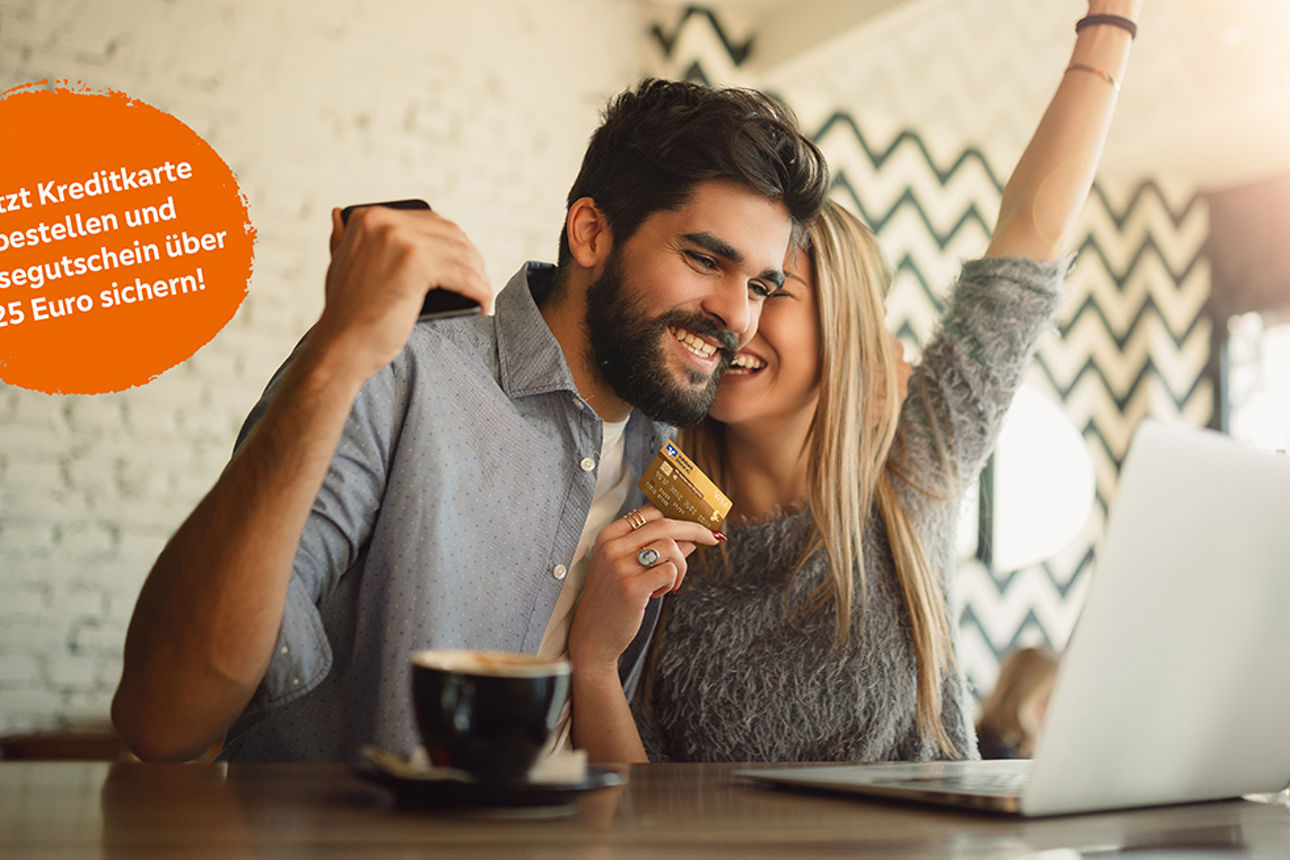 Zwei Junge Menschen sitzen jubelnd mit einer Kreditkarte vor einem Laptop.