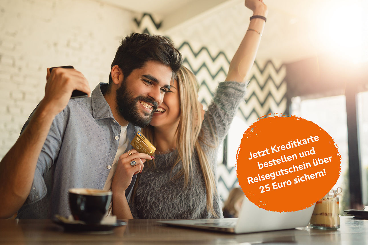 Zwei Junge Menschen sitzen jubelnd mit einer Kreditkarte vor einem Laptop.