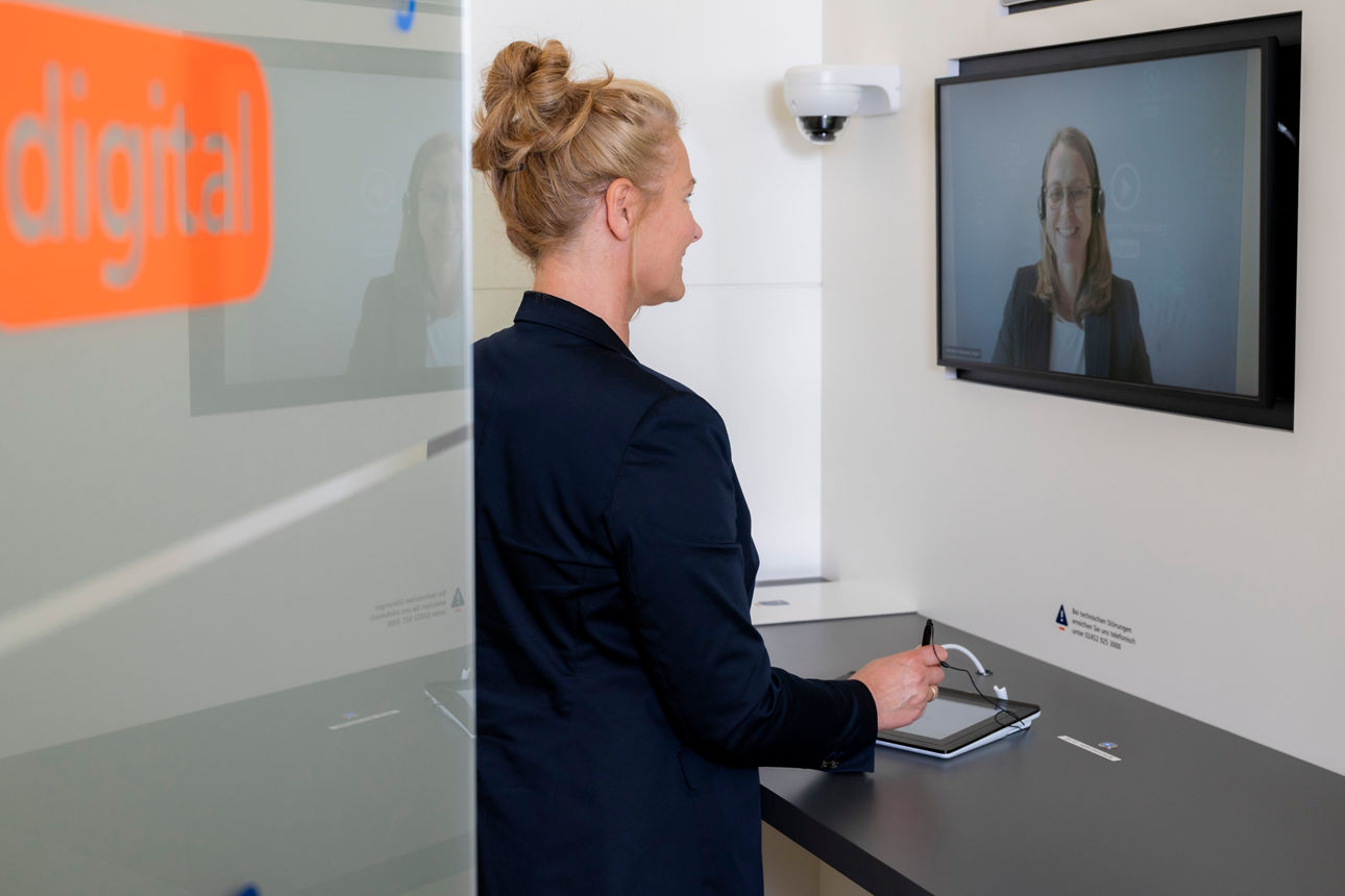 Kundin steht im VR Video Consult und wird digital beraten.