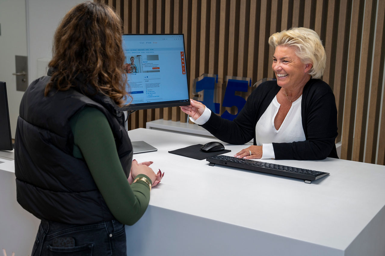 Servicemitarbeiterin zeigt einer Kundin etwas auf dem Bildschirm