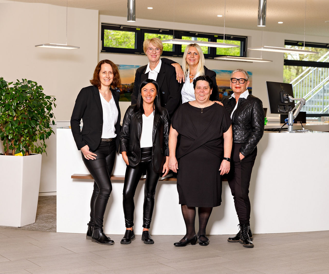 6 schwarz gekleidete Frauen arbeiten in einem Servicecenter