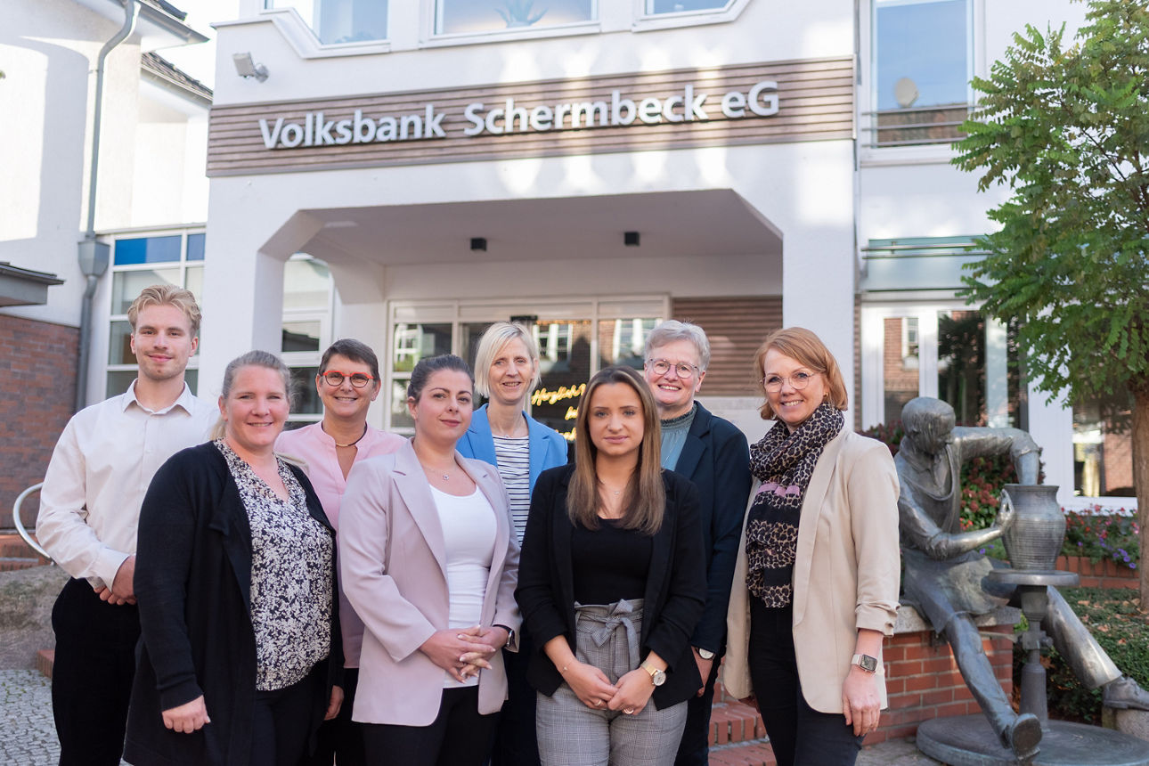 Unser Volksbank Schermbeck Telefonteam bestehend aus sieben Frauen und einem Mann vor dem Gebäude der Volksbank Schermbeck.