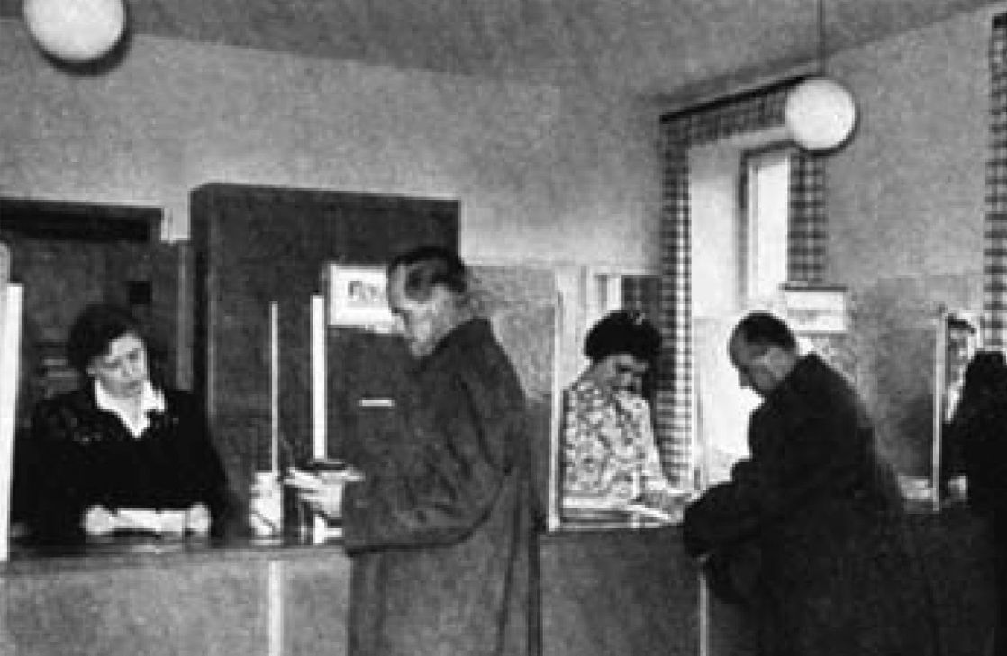 ein altes Bild in Schwarz-Weiß, mehrere Menschen stehen vor einem Bankschalter