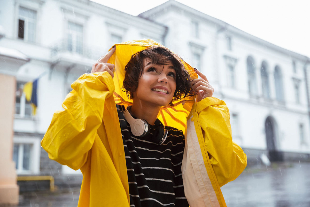 Frau mit Regenmantel im Regen