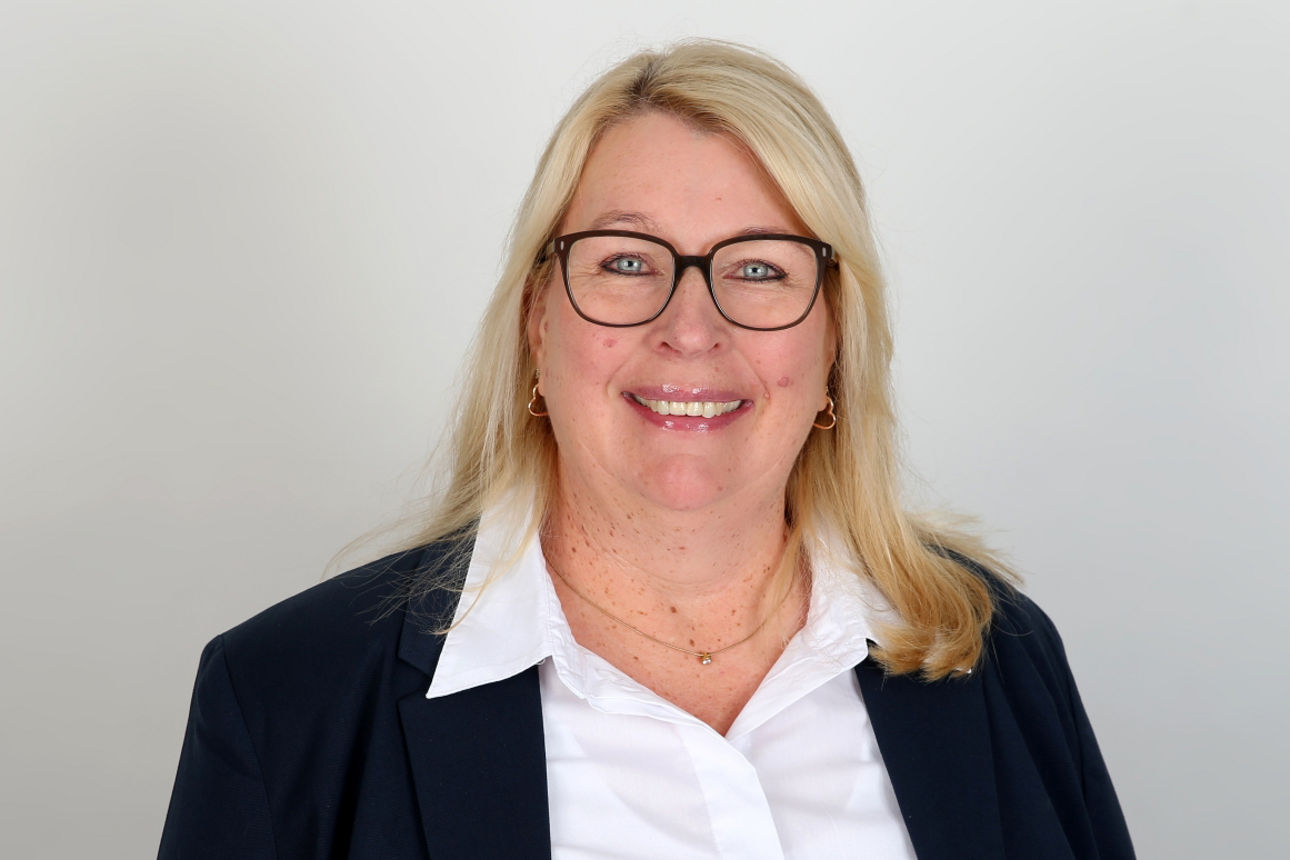 Eine lächelnde Frau schaut in die Kamera.