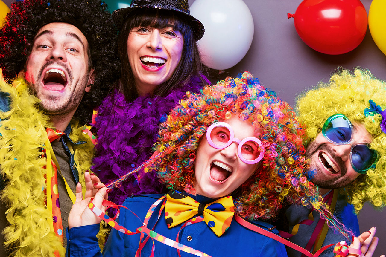 Lachende Freunde in bunten Kostümen feiern Karneval .