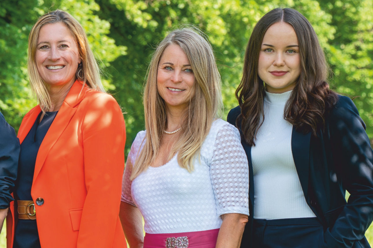 Fünf Mitarbeiter stehen auf einer Wiese