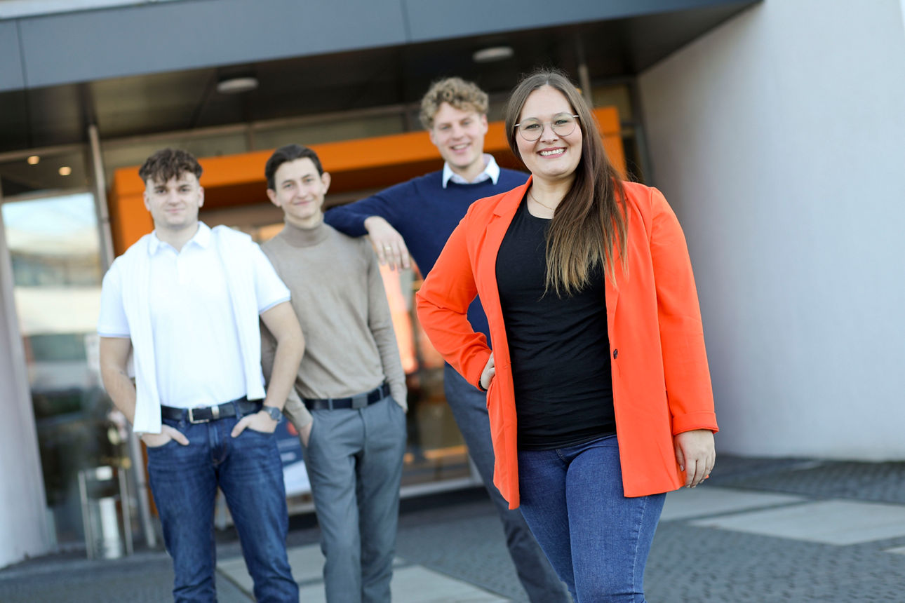 Vier Mitarbeiter der VR-Bank Mittelfranken Mitte stehen nebeneinander, im Vordergrund ist eine Frau lächelnd.