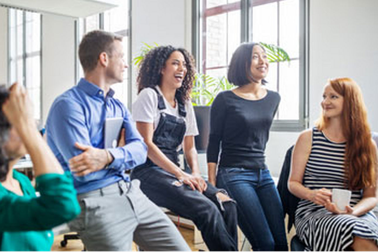 Fünf junge Menschen lachen zusammen