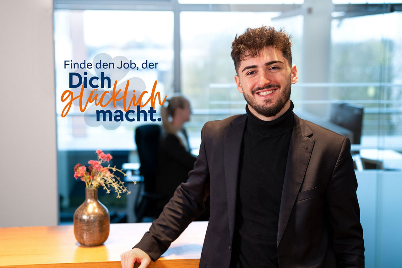 Unser Kollege Arlind lächelt in die Kamera – Finde den Job der dich glücklich macht.