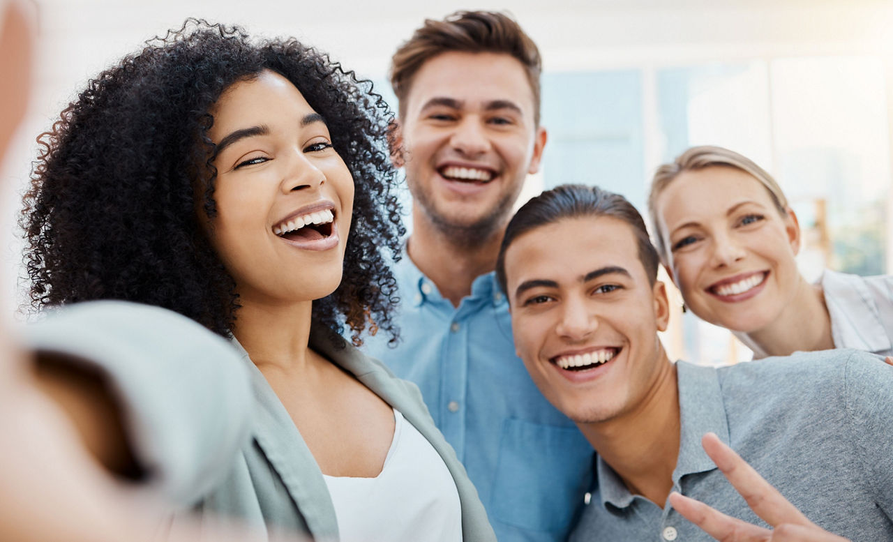 4 junge Menschen die in die Kamera lachen