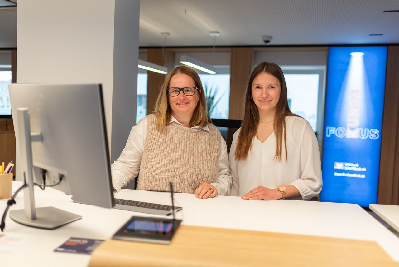 Praktikantin und eine Mitarbeiterinder Volksbank Schermbeck an einem Serviceschalter in einer Bank