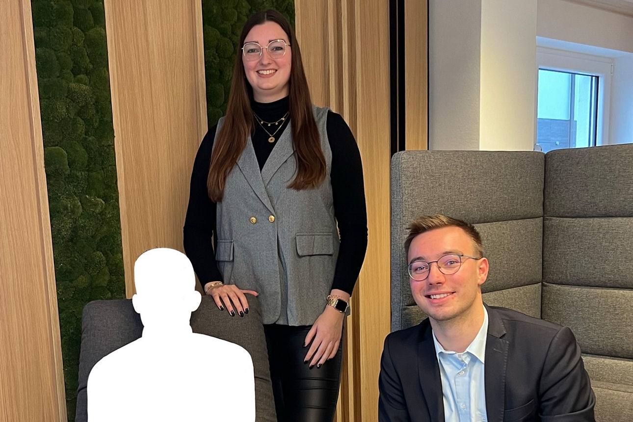 Junge Frau und junger Mann sitzen und stehen lächelnd um weißen Avatar herum. 