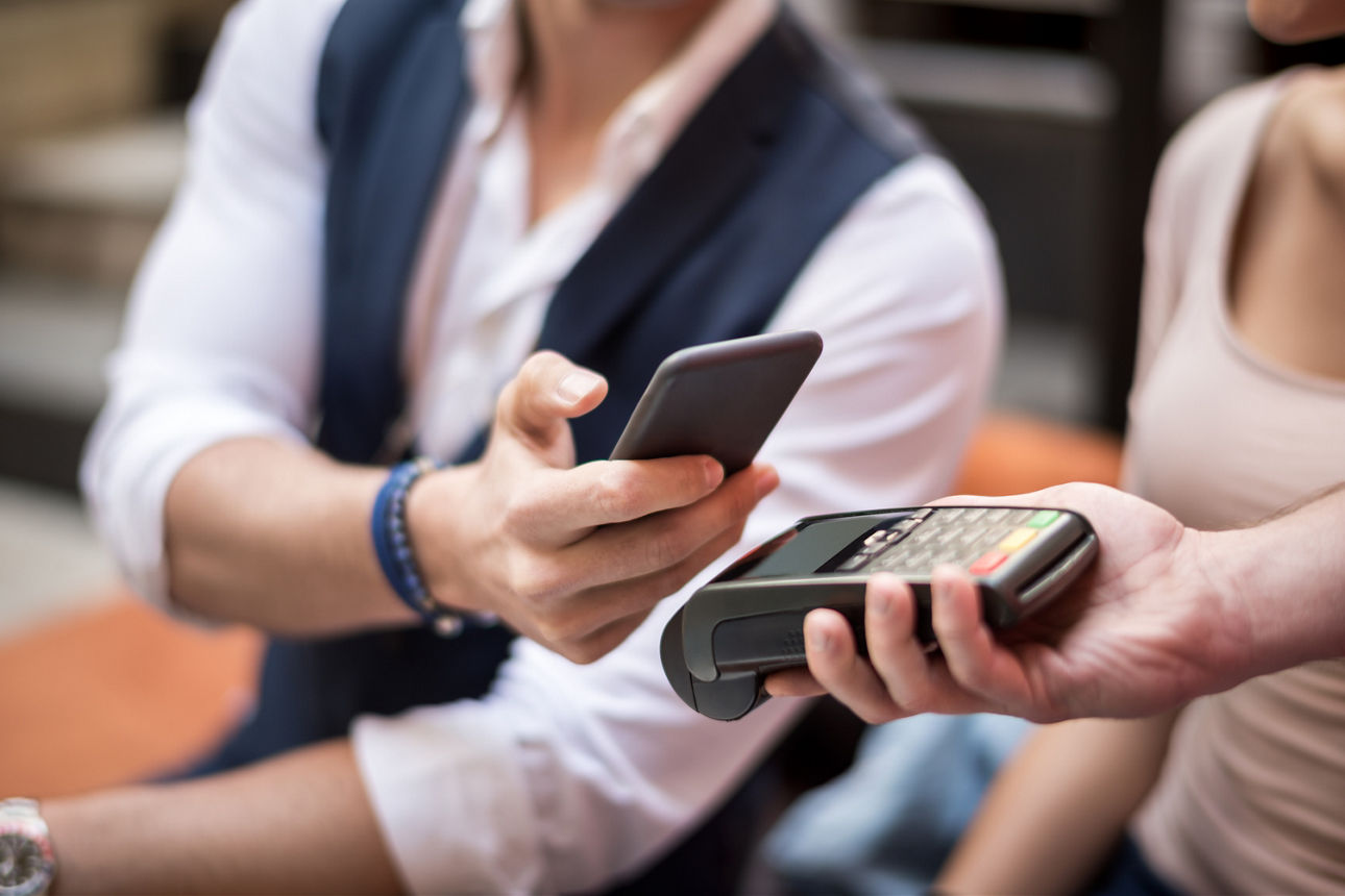 Person hält ihre Karte an ein Lesegerät