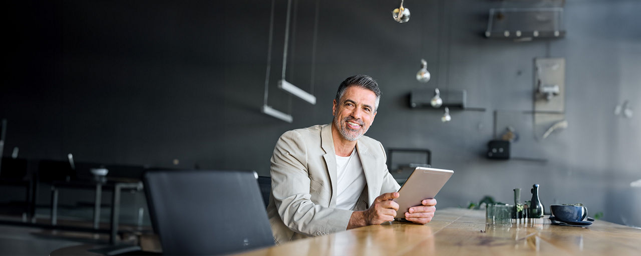 ein Mann der ein Tablet in der Hand hält