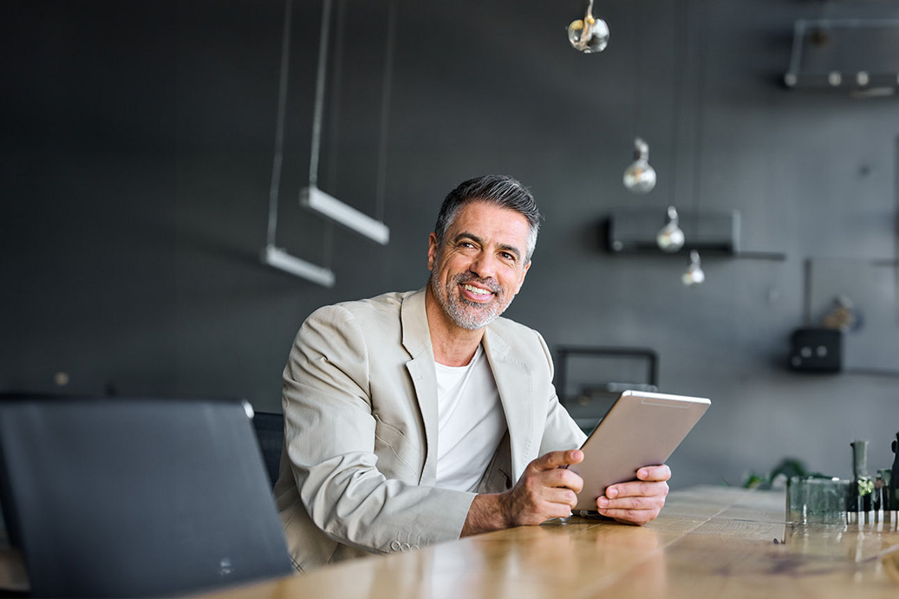 ein Mann der ein Tablet in der Hand hält