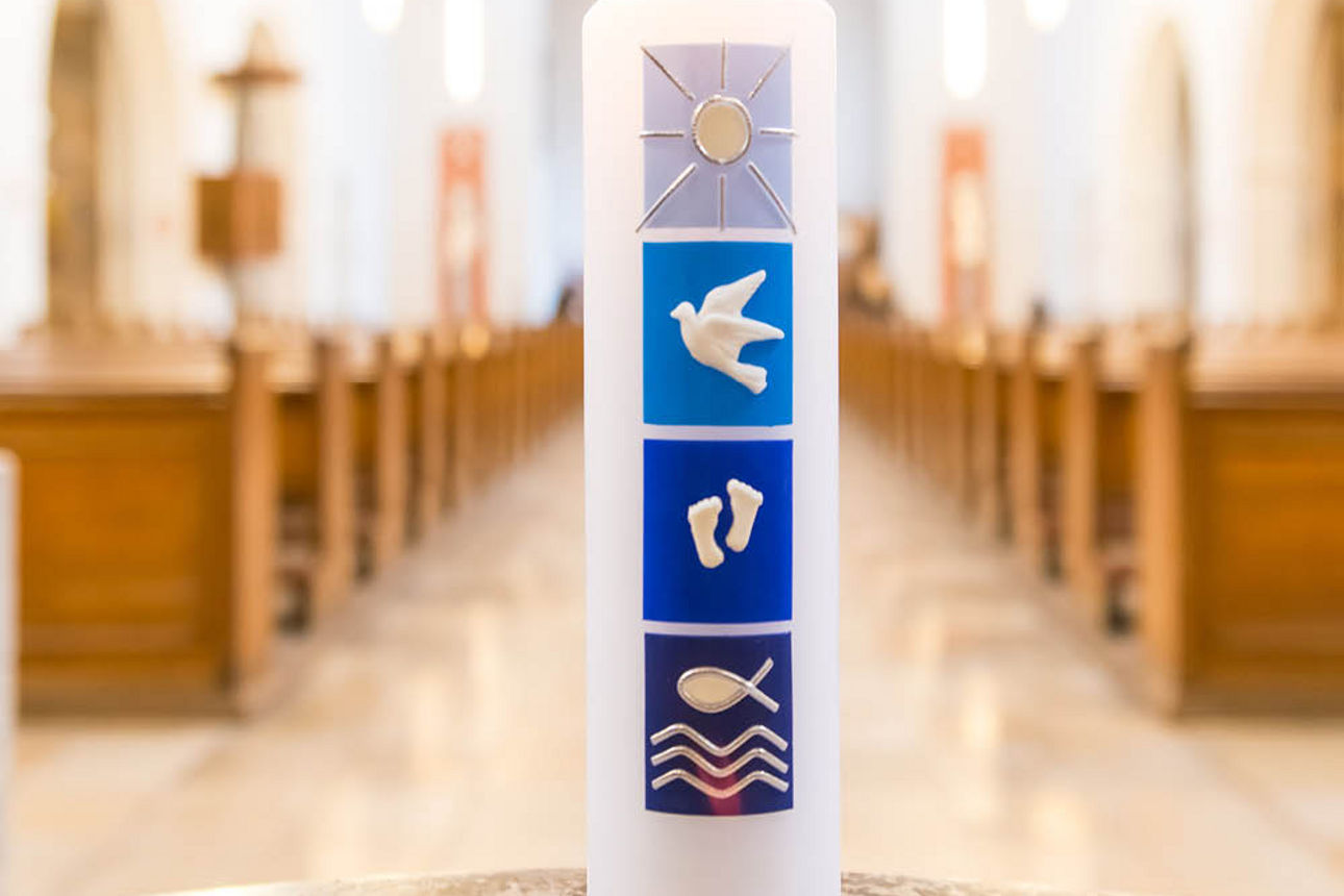 Eine Kerze mit Sitzbänken einer Kirche im Hintergrund.