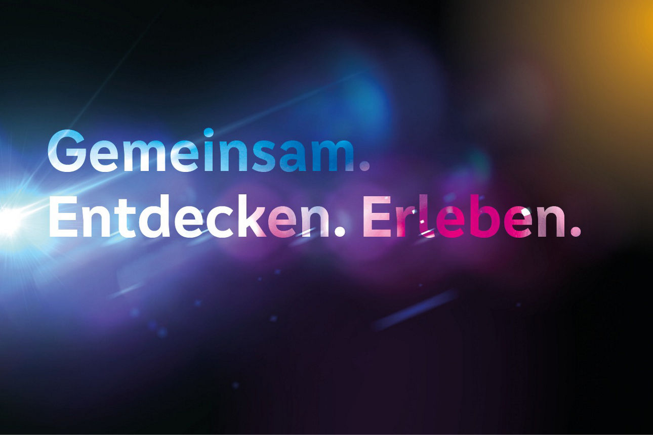 Schriftzug "Gemeinsam. Erleben. Entdecken" auf schwarzem Hintergrund