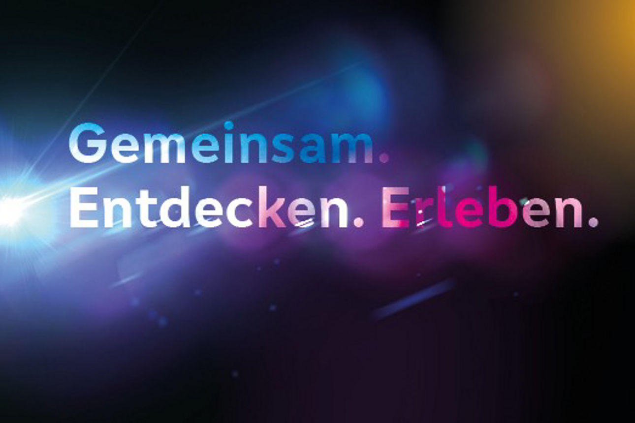 Schriftzug "Gemeinsam. Erleben. Entdecken" auf schwarzem Hintergrund