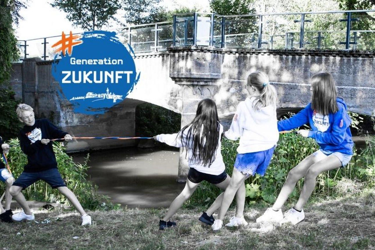 Kids spielen Tauziehen am Bach
